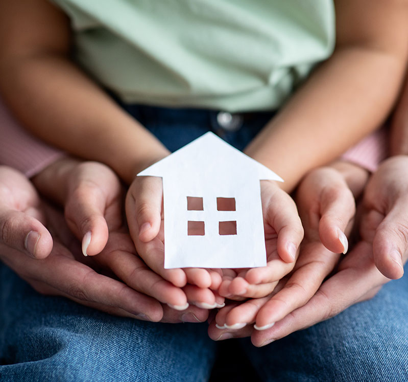 Image showing a close up of a family of 3 holding a model house in their hands