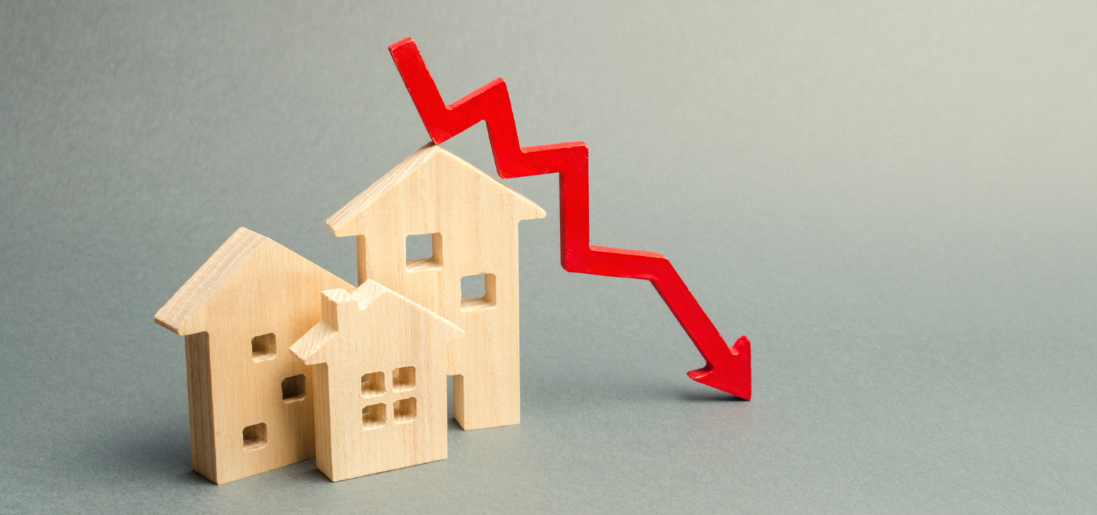 miniature wooden houses with a red arrow down