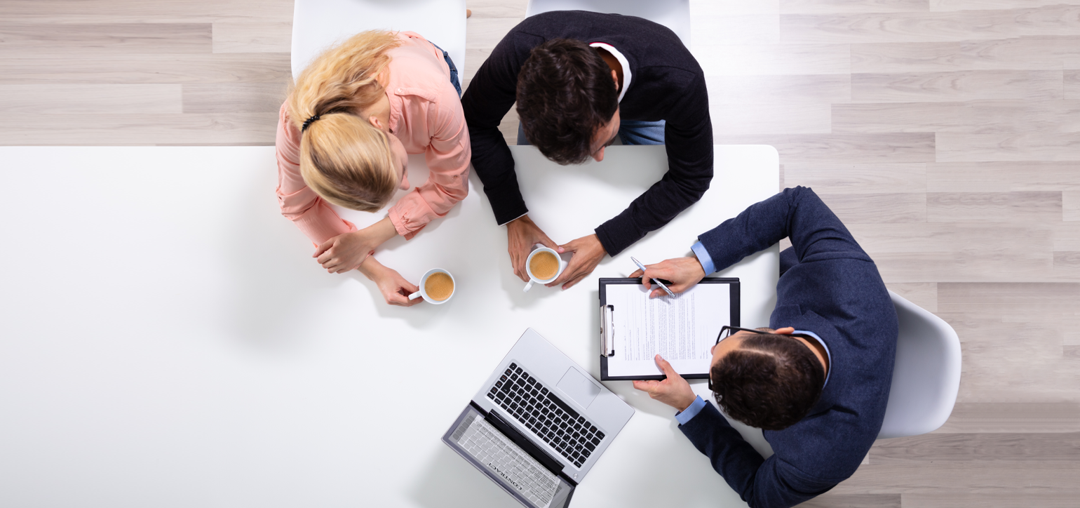 financial adviser sitting with couple at a table