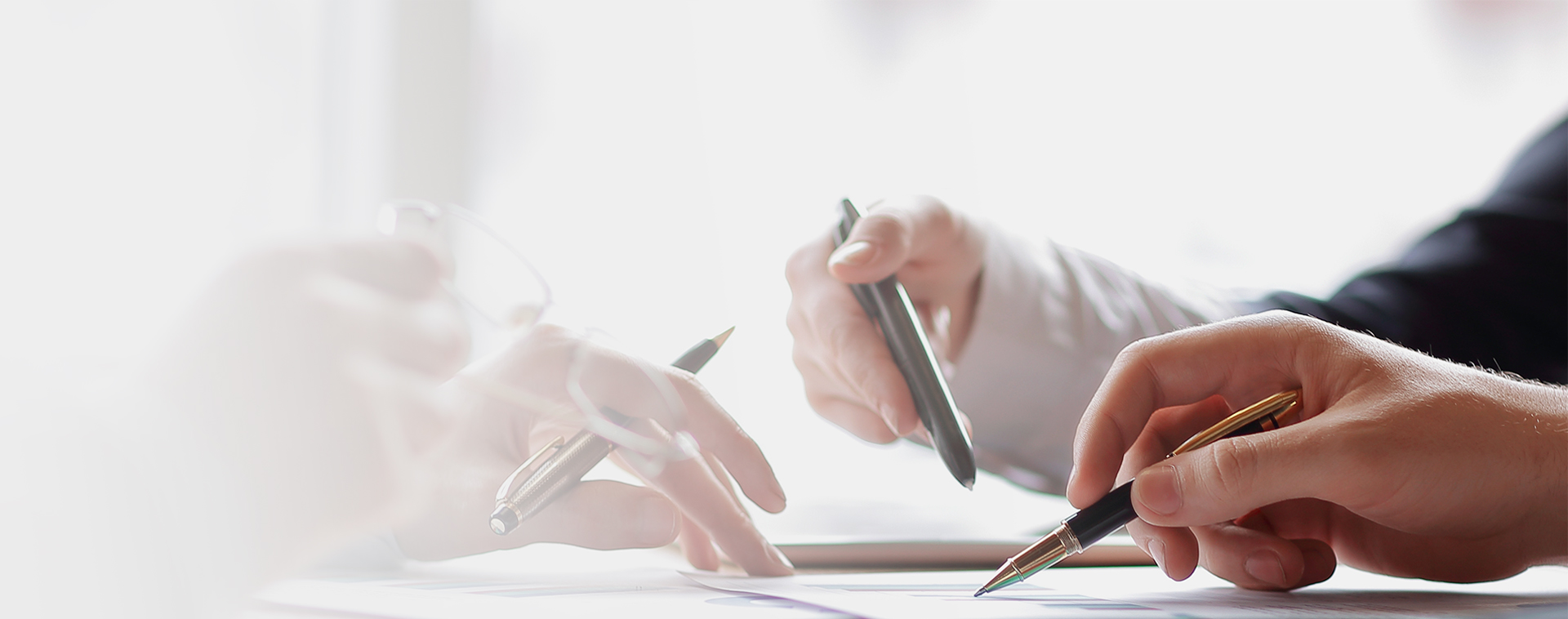 Close up of 3 people in a business meeting looking at some paperwork