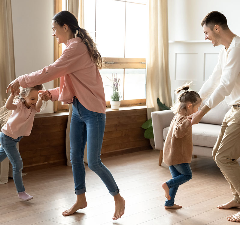 Image showing a family of 4 dancing together in their front room