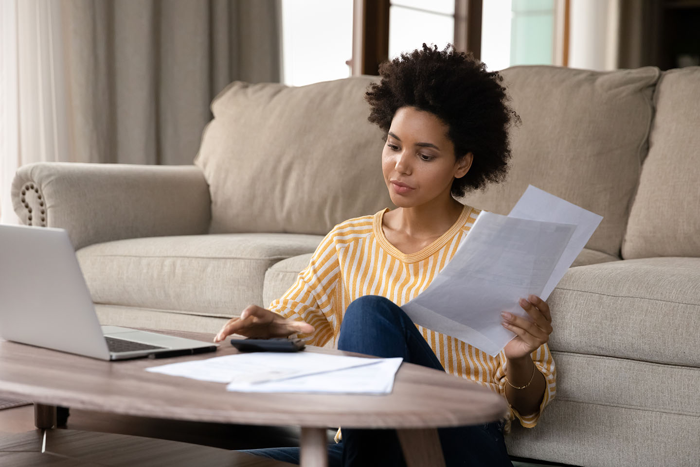 Image showing a woman sitting on her floor looking at paperwork