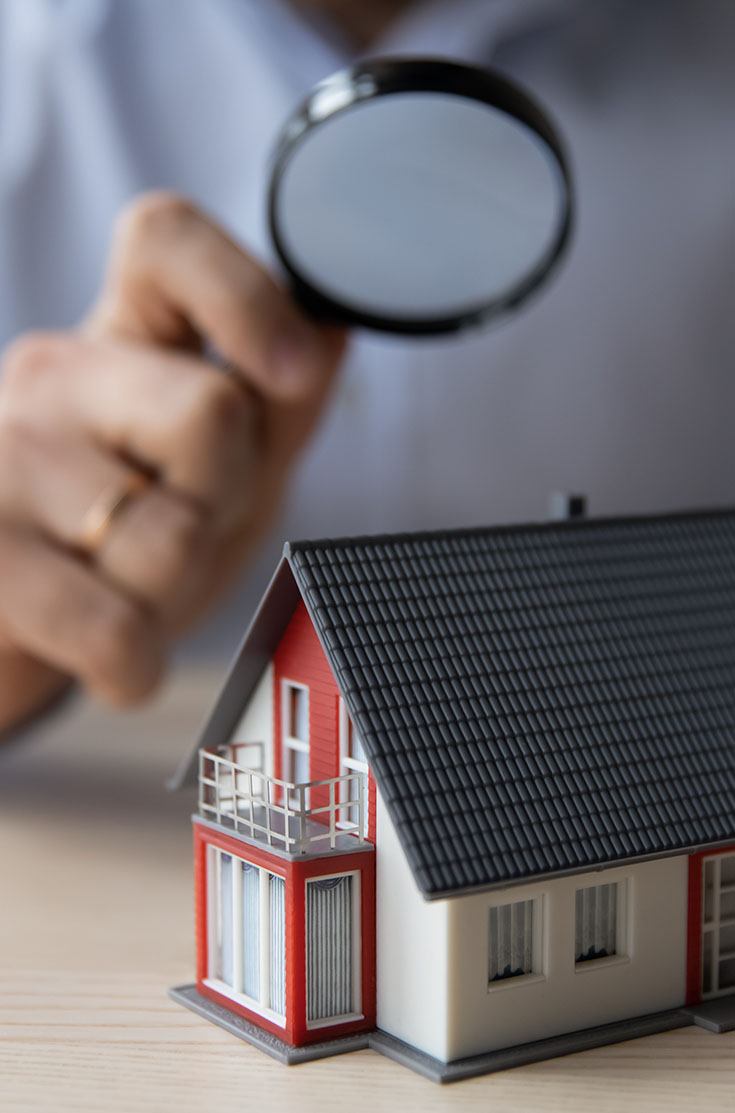 Image showing a model house being looked at through a magnifying glass