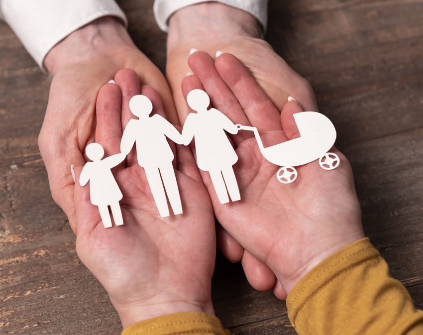 Concept of family insurance with paper family in hands
