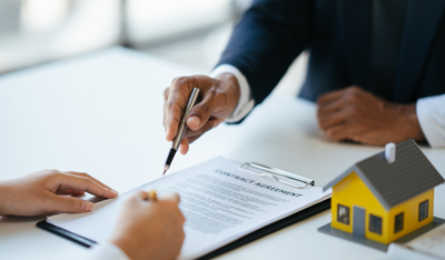 image showing hands with a pen and a tiny house
