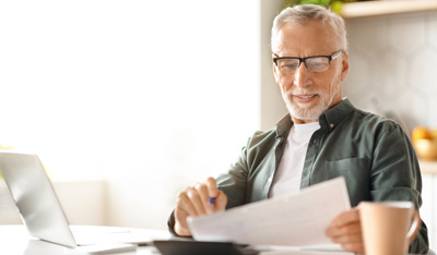 Senior man checking financial documents and calculating