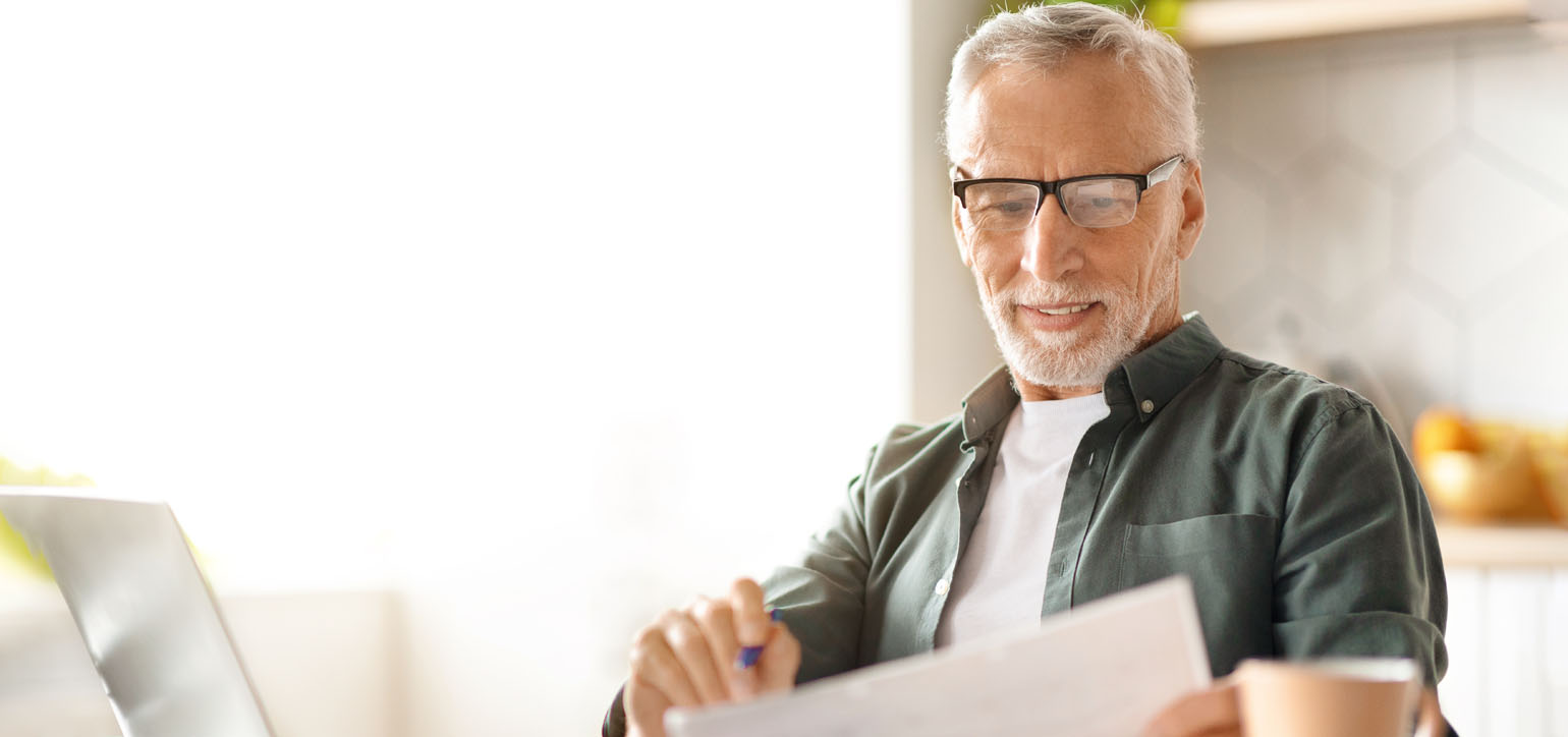 Senior man checking financial documents and calculating
